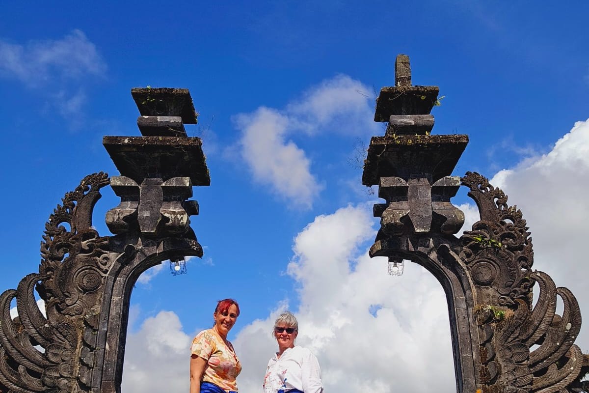 Tamu berfoto di depan candi bentar, gapura khas Bali